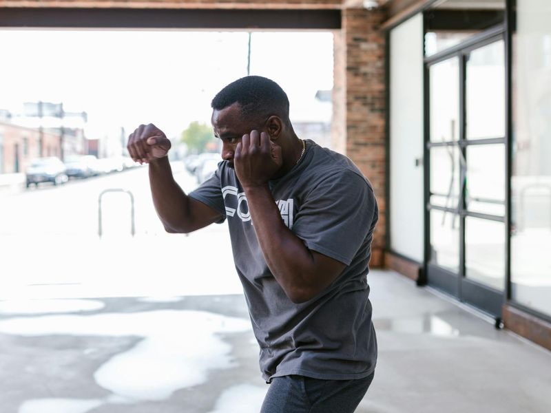 Man in a focused stance, preparing for a bodyweight exercise.
