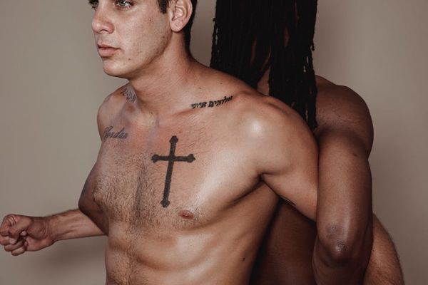 Man performing a controlled bodyweight exercise in a minimalist gym setting.